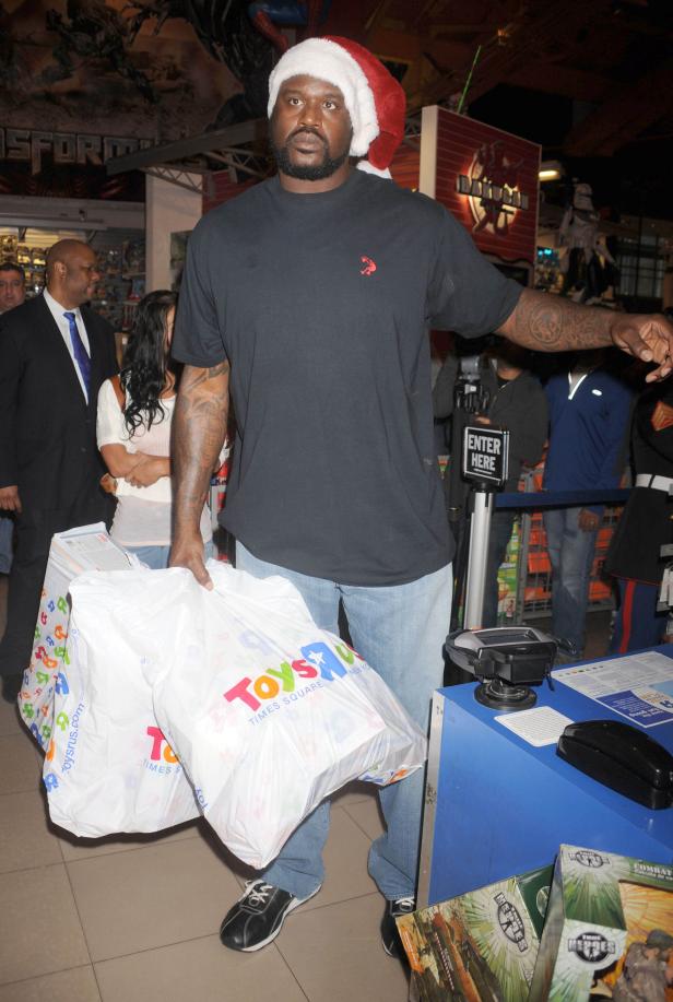 Shaquille O'Neal mit Weihnachtsmütze und Einkaufstüten von Toys „R“ Us.