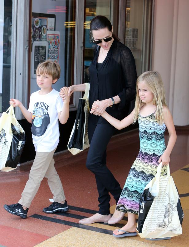 Angelina Jolie mit ihren Kindern, die Einkaufstüten von „Barnes & Noble“ tragen.