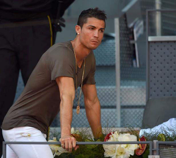 Cristiano Ronaldo lehnt an einem Geländer mit Blumen und blickt nachdenklich zur Seite.