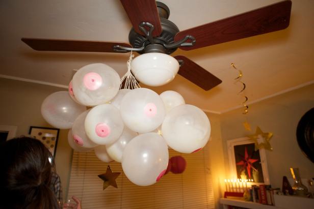 Eine Gruppe weißer Ballons mit rosa Kreisen hängt an einem Deckenventilator.