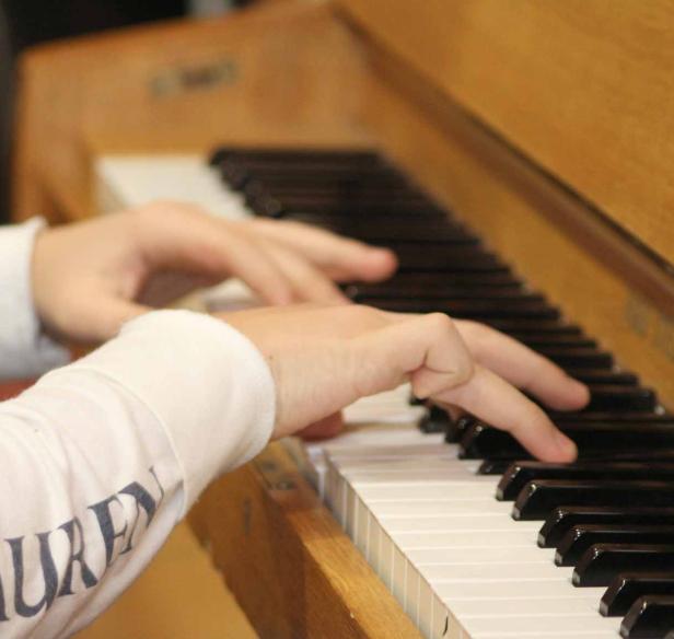 Zwei Hände auf einer Klaviertastatur.