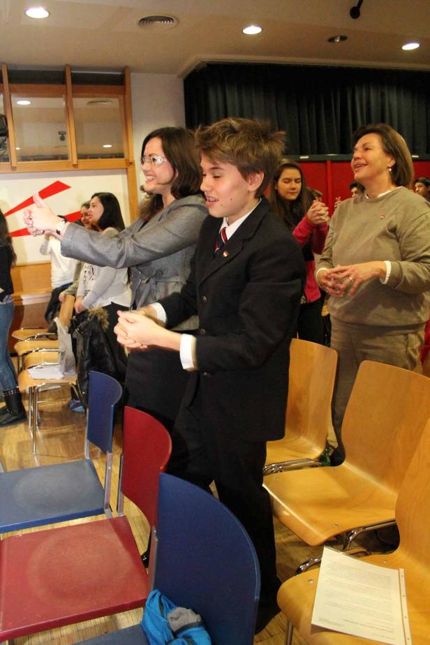 Eine Gruppe von Menschen klatscht in einem Raum Applaus.