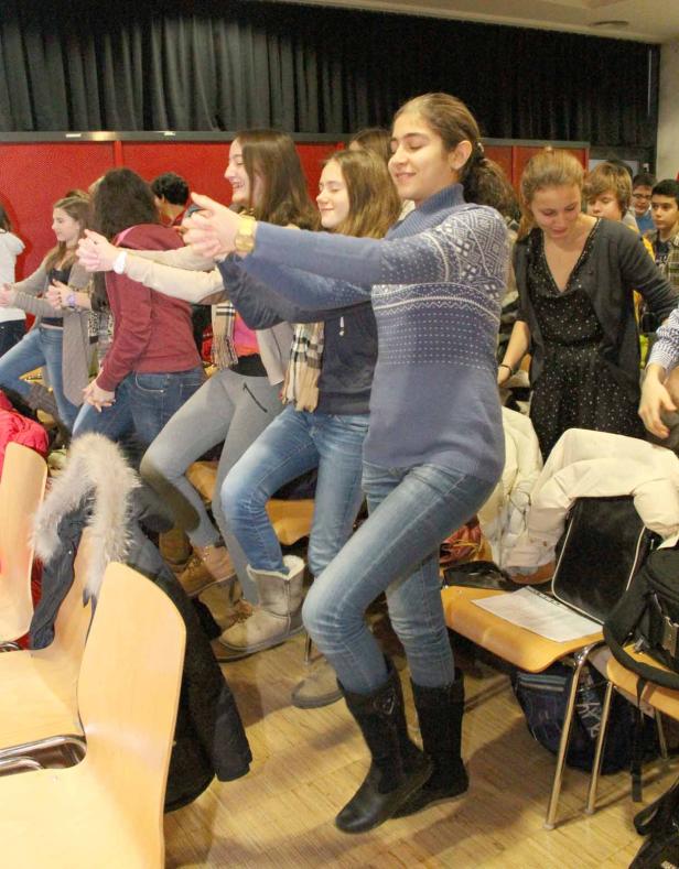 Eine Gruppe junger Leute tanzt gemeinsam in einem Raum.