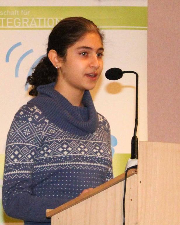 Ein junges Mädchen spricht an einem Rednerpult mit Mikrofon.