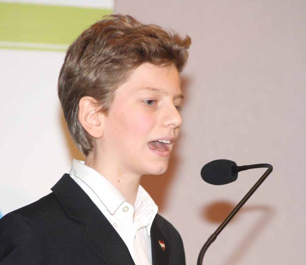 Ein junger Mann spricht in ein Mikrofon.