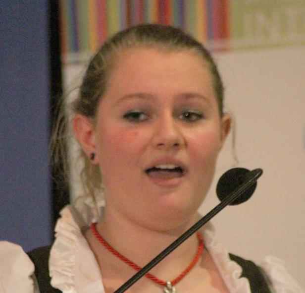 Eine junge Frau spricht in ein Mikrofon.