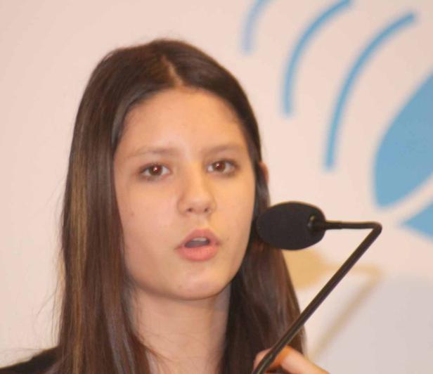 Ein junges Mädchen spricht in ein Mikrofon.