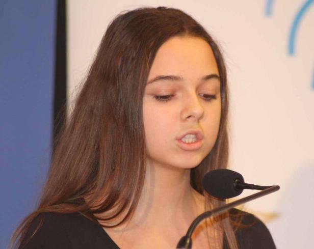 Ein junges Mädchen spricht in ein Mikrofon.