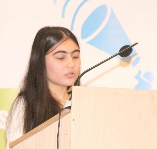 Eine junge Frau spricht an einem Rednerpult.