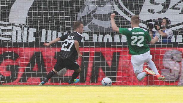 Zwei Fußballspieler während eines Spiels vor einem Tornetz.