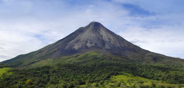 Der Vulkan Arenal in Costa Rica ragt über einen üppigen grünen Wald hinaus.