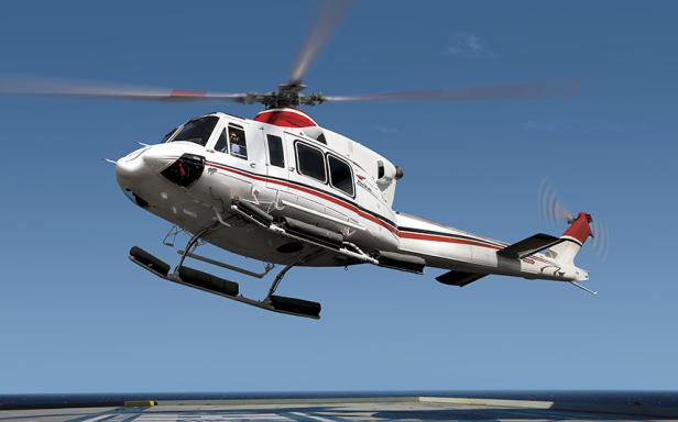 Ein weißer Hubschrauber mit roten Akzenten landet auf einer Plattform.