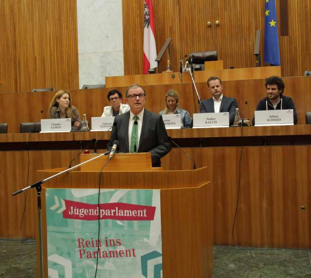 Ein Mann spricht am Rednerpult während einer Sitzung des Jugendparlaments.