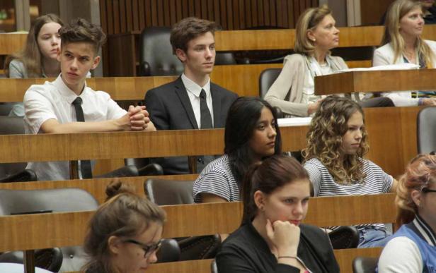 Eine Gruppe junger Menschen sitzt in einem Auditorium.