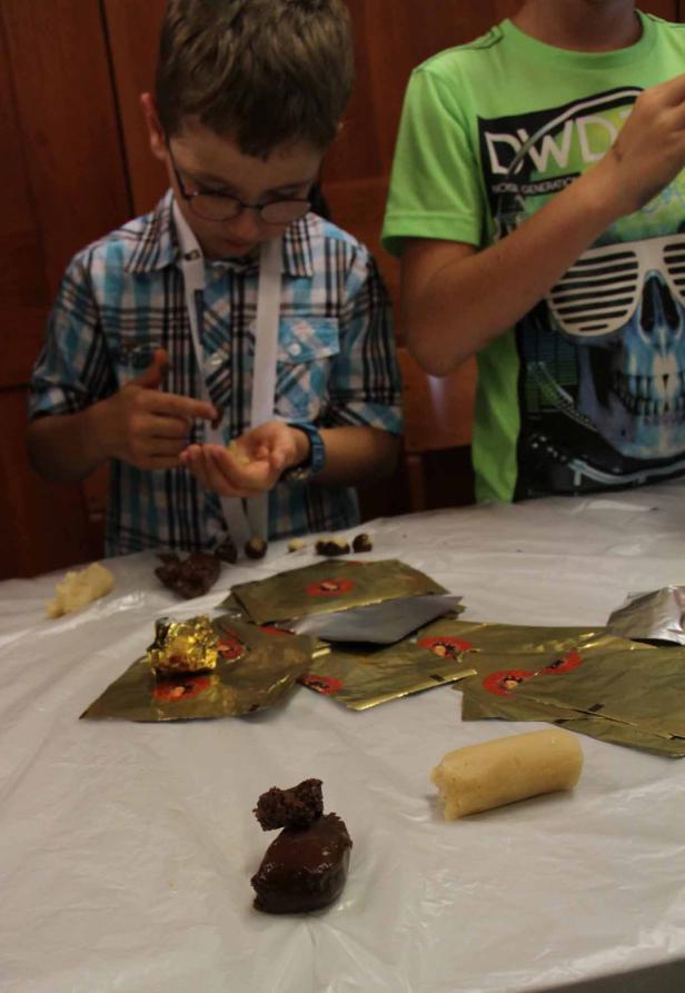 Zwei Kinder formen Süßigkeiten aus Marzipan und Schokolade.
