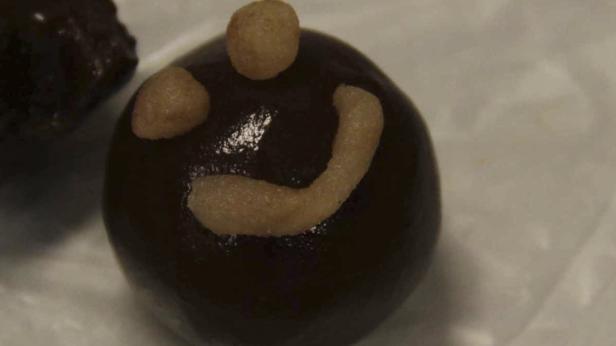 Ein Schokoladenkuchen mit einem Smiley-Gesicht aus hellbraunem Zuckerguss.