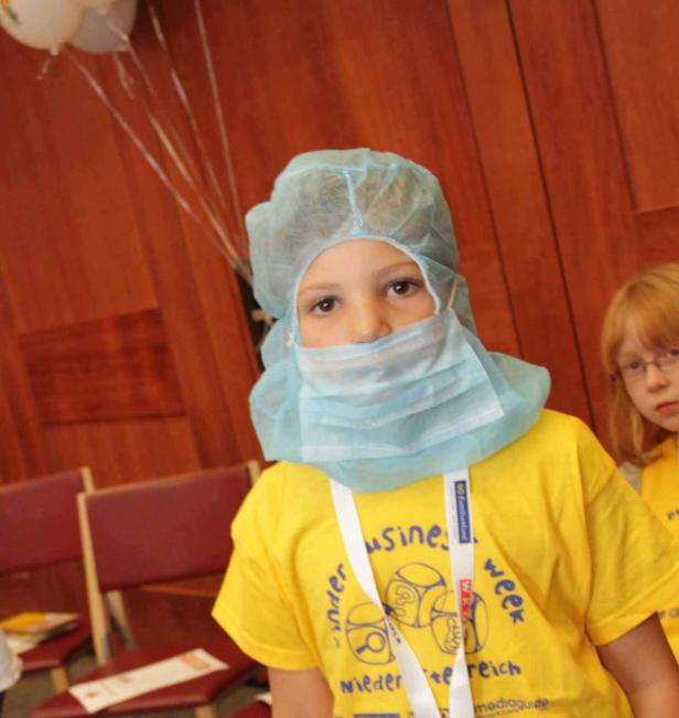 Ein Kind mit Mundschutz und Haube, möglicherweise als Arzt verkleidet.