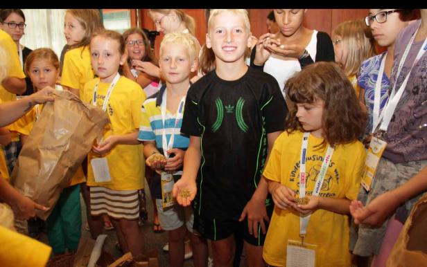 Eine Gruppe Kinder hält Samen in ihren Händen.