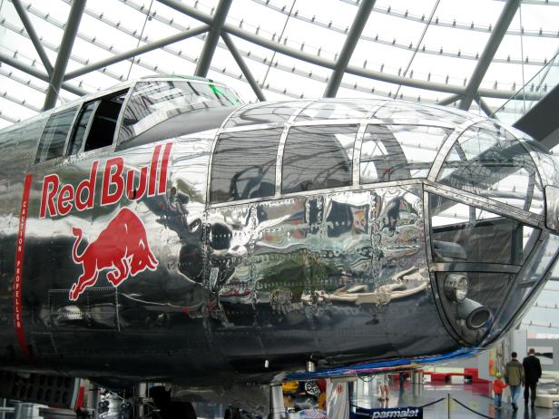 Die glänzende Red Bull B-25 Mitchell steht in einer Ausstellungshalle.