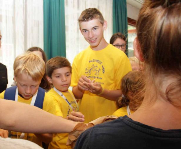 Eine Gruppe von Kindern in gelben T-Shirts interagiert miteinander.