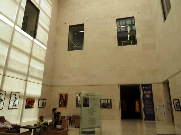 Im Leopold Museum sitzen Menschen und betrachten Kunstwerke an den Wänden.