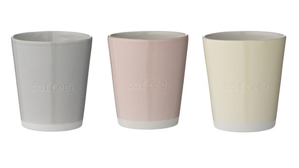 Drei Kaffeetassen in Grau, Rosa und Beige mit der Aufschrift „coffee.“.