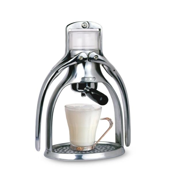 Eine manuelle ROK Espressomaschine mit einer Tasse Milchkaffee.
