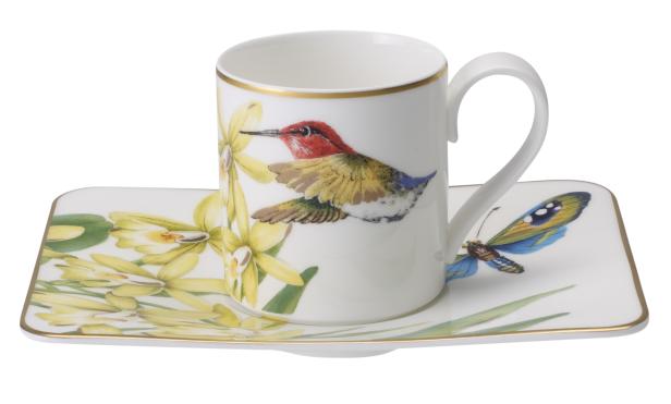 Eine Tasse und Untertasse mit einem Kolibri-, Schmetterlings- und Orchideenmuster.