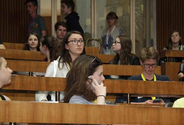 Zahlreiche junge Menschen sitzen in einem Hörsaal.