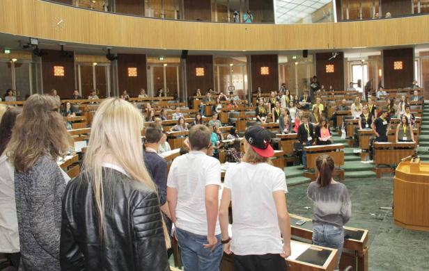 Jugendliche stehen im österreichischen Parlament während einer simulierten Sitzung.