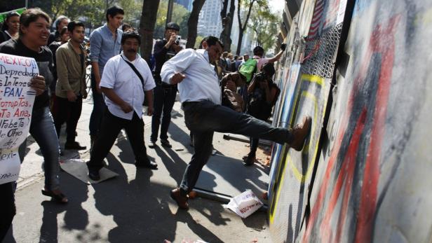 Ein Mann tritt gegen eine Wand während einer Demonstration.