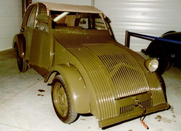 Ein olivgrünes Auto mit ungewöhnlicher, gerippter Karosserie steht in einer Garage.