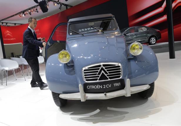 Ein blauer Citroën 2 CV von 1961 steht auf einer Ausstellung.