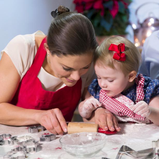 Eine Mutter backt mit ihrer kleinen Tochter Weihnachtsplätzchen.