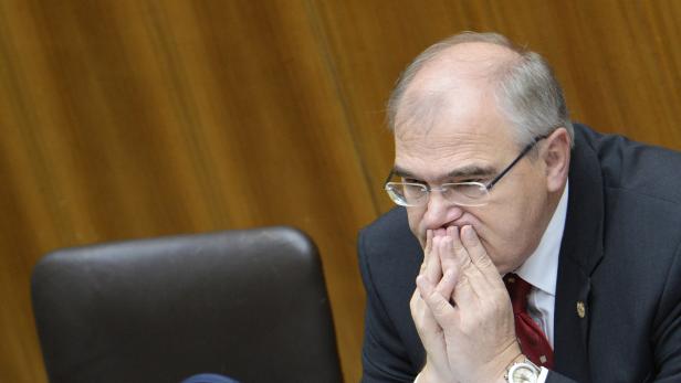 Justizminister Brandstetter Ein Mann mit Brille und Anzug hält die Hände vor das Gesicht.