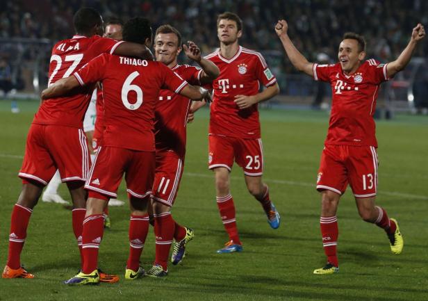 Fußballspieler des FC Bayern München feiern auf dem Rasen.