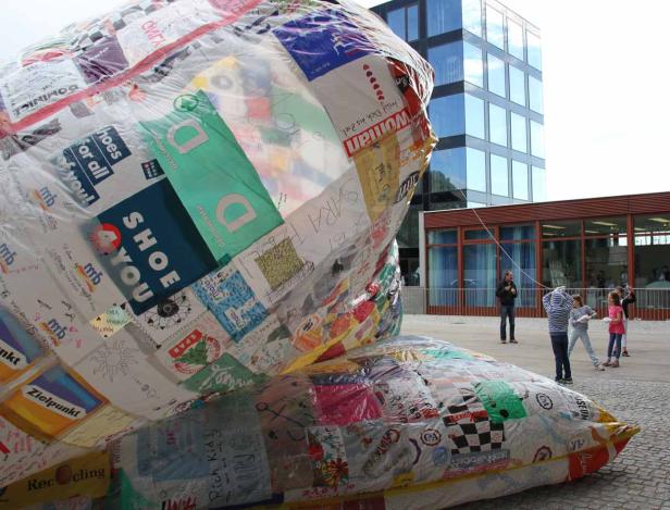 Eine große, mit Logos und Zeichnungen beklebte Balloninstallation im Freien.