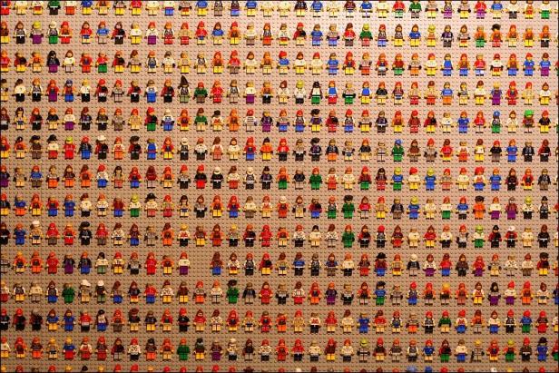 Eine große Sammlung von Lego-Figuren auf einer grauen Grundplatte.