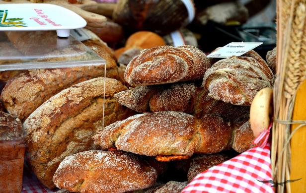 Verschiedene Brotsorten liegen auf einem rot-weiß karierten Tuch zum Verkauf aus.