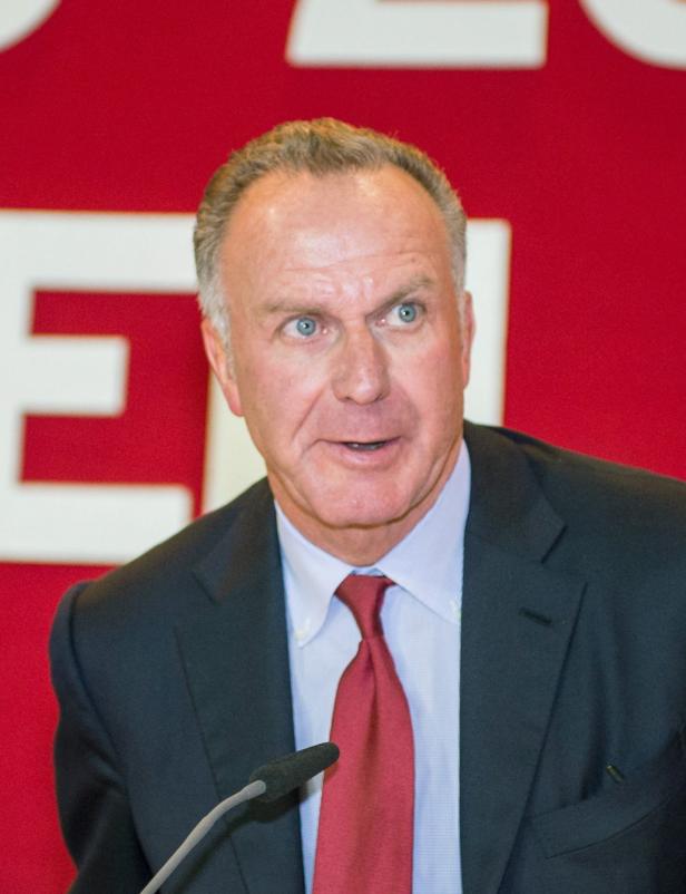 Uli Hoeneß bei einer Rede vor einem roten Hintergrund.