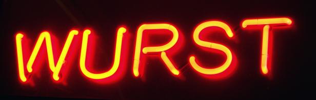 Ein rotes Neon-Schild zeigt das Wort „Wurst“.
