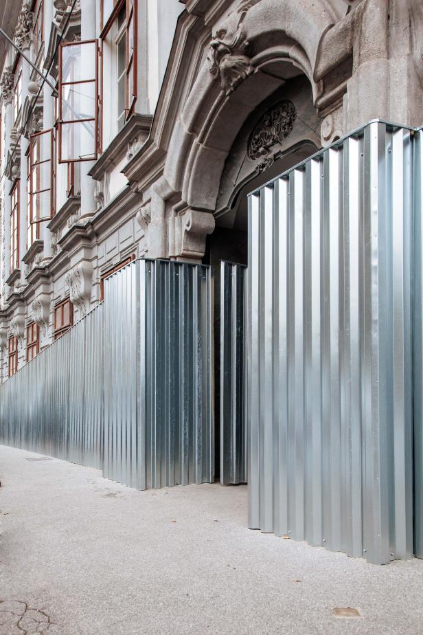 Ein Gebäude mit einer Fassade, die durch eine Metallbarriere geschützt ist.