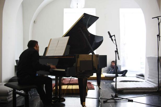 Ein Mann spielt auf einem schwarzen Bösendorfer-Flügel, während eine Frau zuhört.