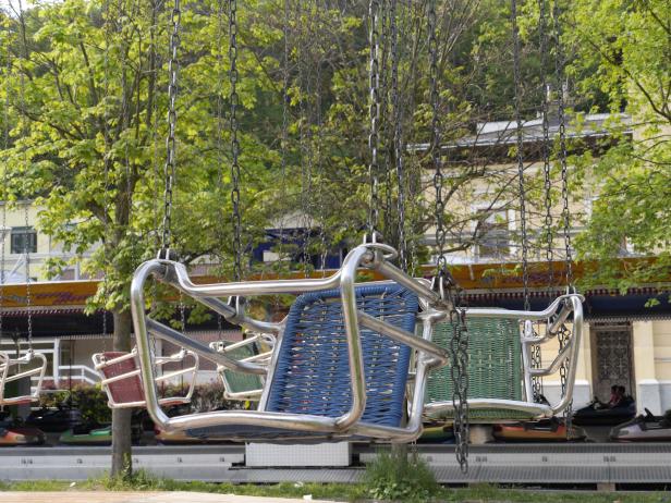 Ein Kettenkarussell mit bunten Sitzen auf einem Jahrmarkt.