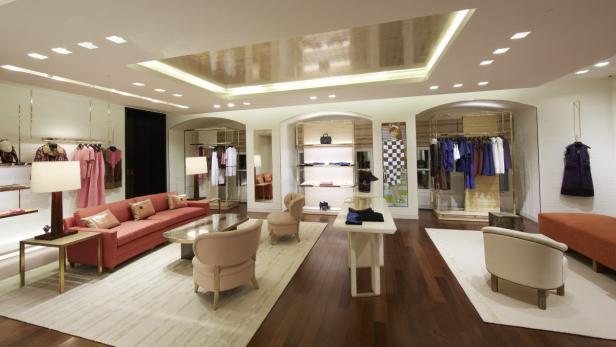 Ein luxuriöses Bekleidungsgeschäft mit Kleidung, Sitzgelegenheiten und Regalen.