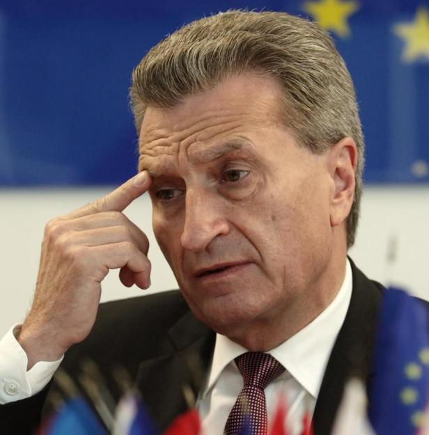 Ein Mann in Anzug und Krawatte denkt nach, die Hand an der Stirn.