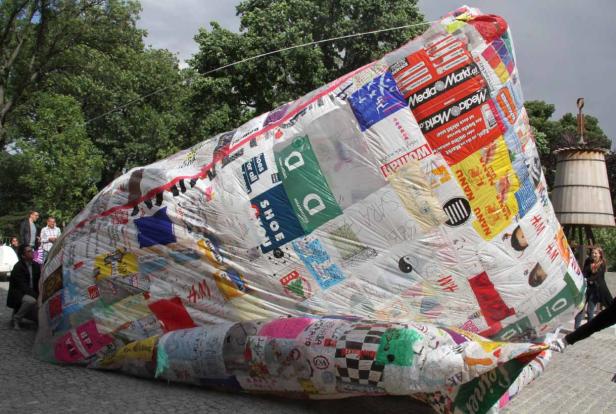 Eine große, mit Logos und Schriftzügen beklebte Installation im Freien.