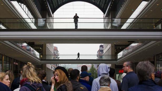 Menschenmenge in einem Einkaufszentrum mit Personen auf verschiedenen Ebenen.