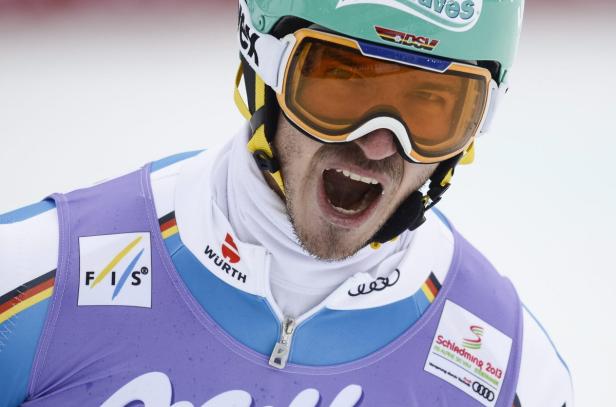 Ein Skirennläufer mit offenem Mund, der einen Helm und eine Skibrille trägt.