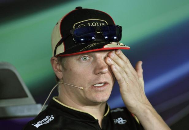 Kimi Räikkönen mit einer Lotus-Kappe reibt sich das Auge.